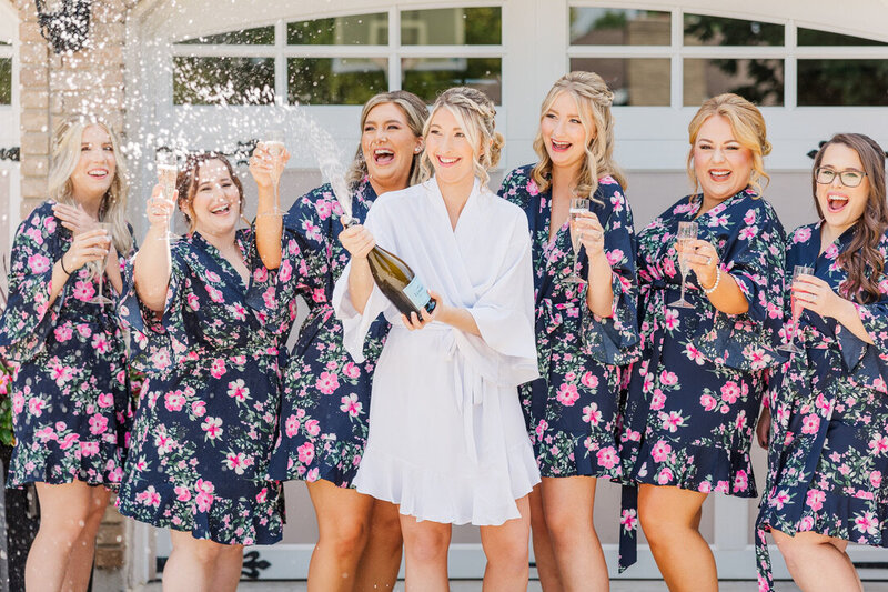 Bridal party getting ready in robes popping chapagne