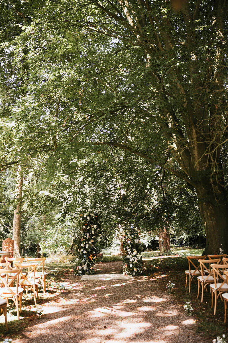 Outdoor wedding ceremony at Broadfield Court with a split arch of flowers