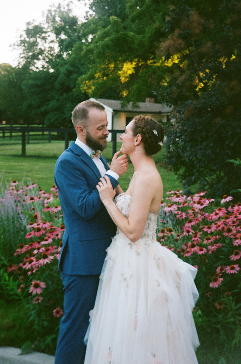 bride and groom smiling together with flowers at Spain Ranch