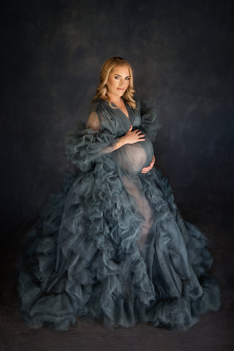 stunning blonde woman holing baby bump belly