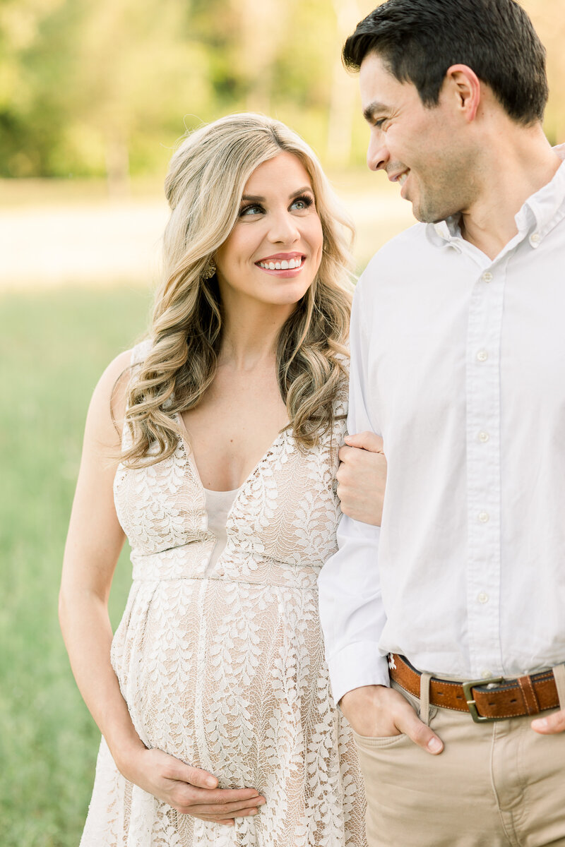 a pregnant woman with her arm linked around her husband's
