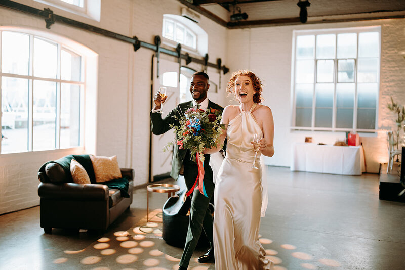 bride and groom walking into reception with eveybody clapping