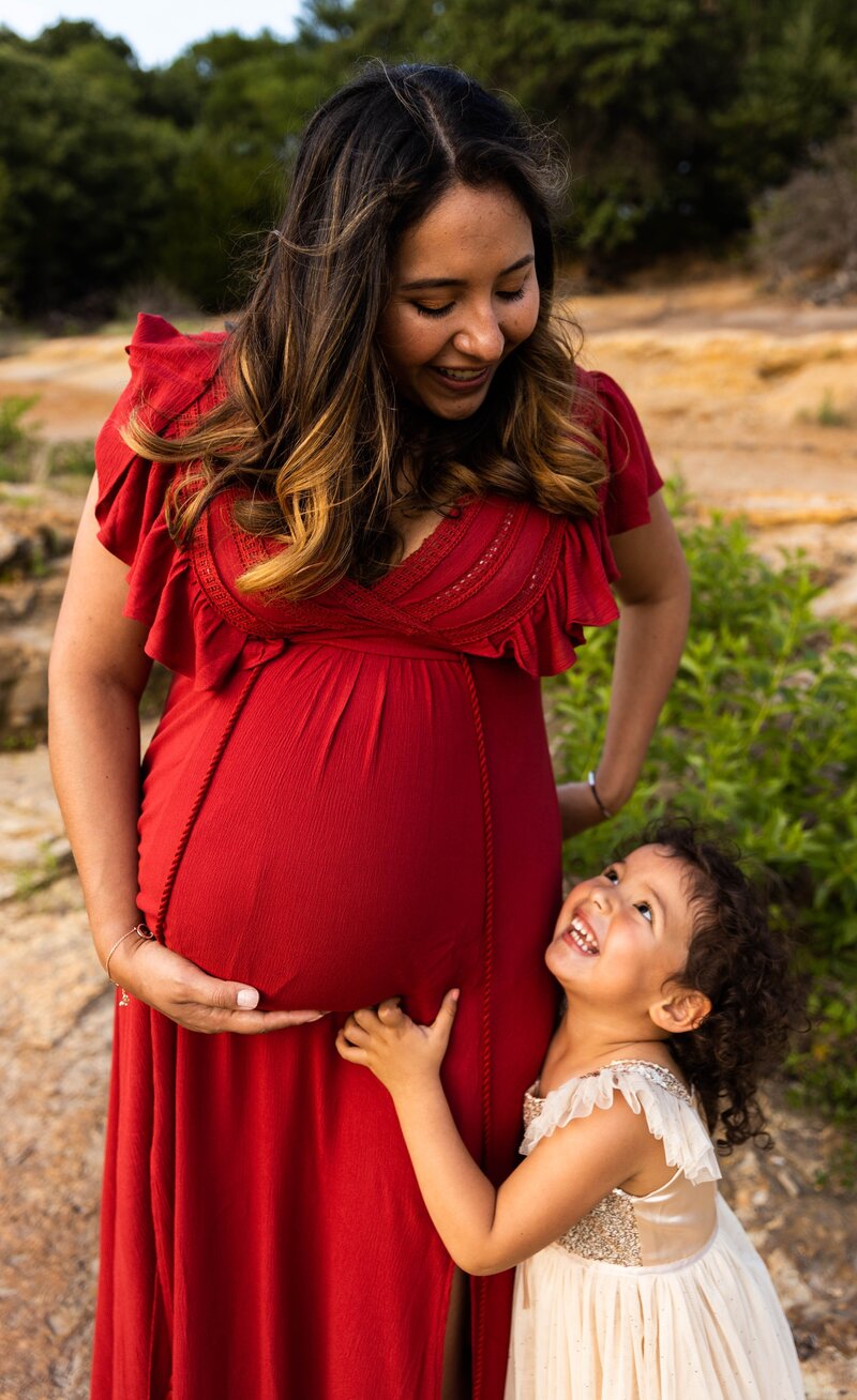 Little girl smiling at pregnant mama