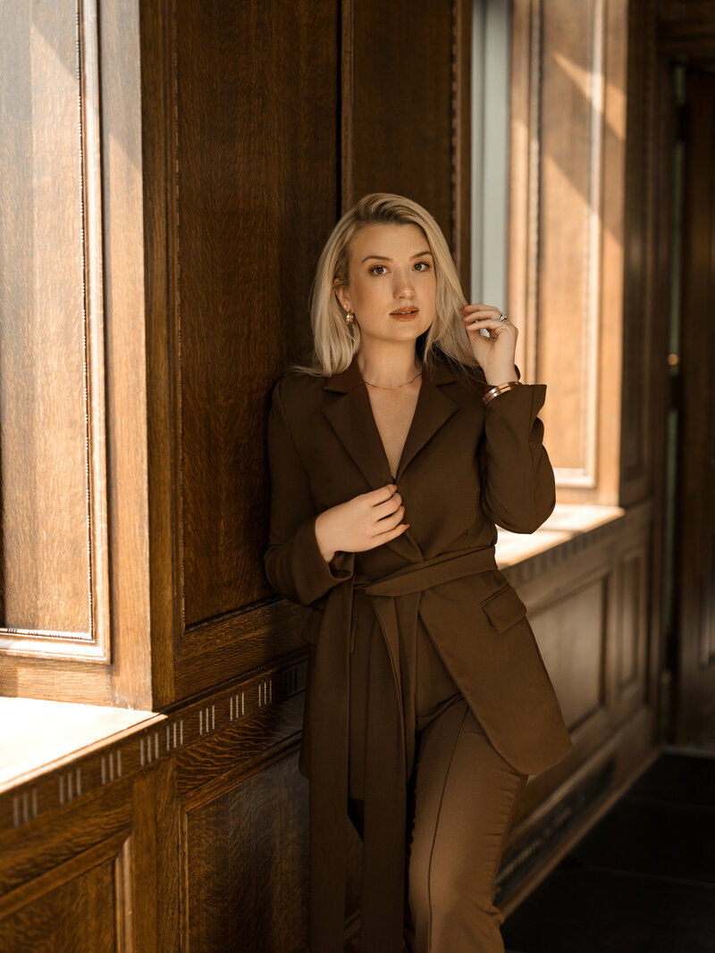 Cate Autumn holding a coffee mug and wearing a blazer