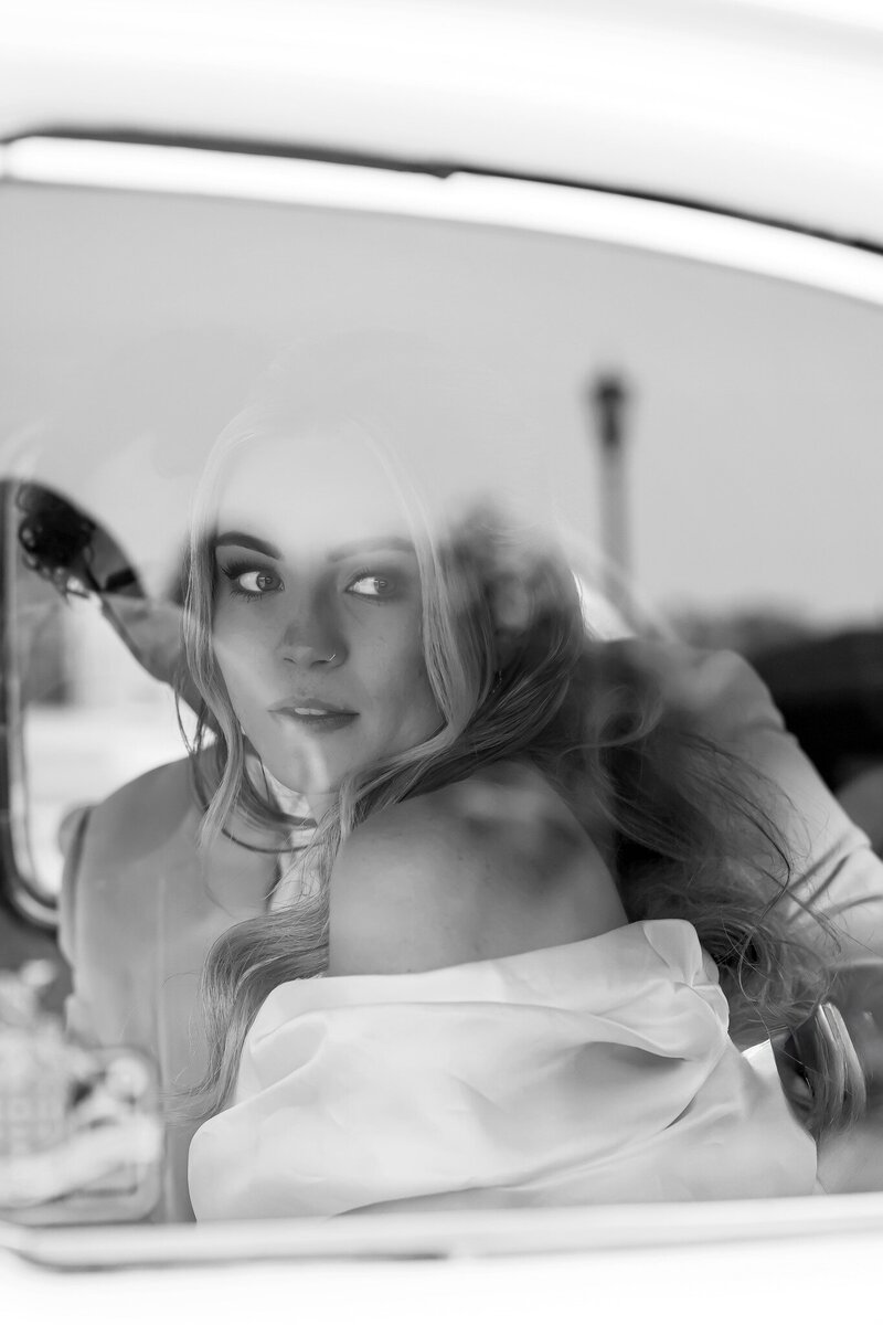Detroit wedding photographer. Editorial, documentary wedding photographer. Bride looking out the window of a classic car at the War Memorial 
