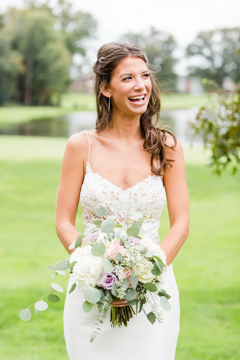 Bride holding her wedding bouquet looking off into the distance.  Photo taken by wedding photographer from akron ohio