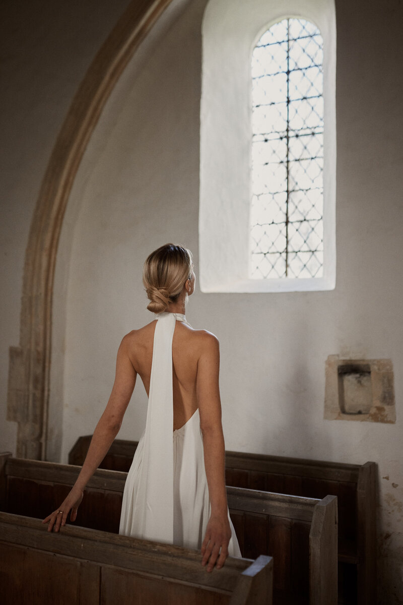 Sleeveless silk halter neck wedding dress by UK bridal gown designer on bride