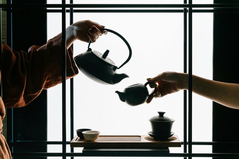 Close-up of two people sharing tea in a traditional Japanese tea ceremony, symbolizing connection, calm, and cultural appreciation.