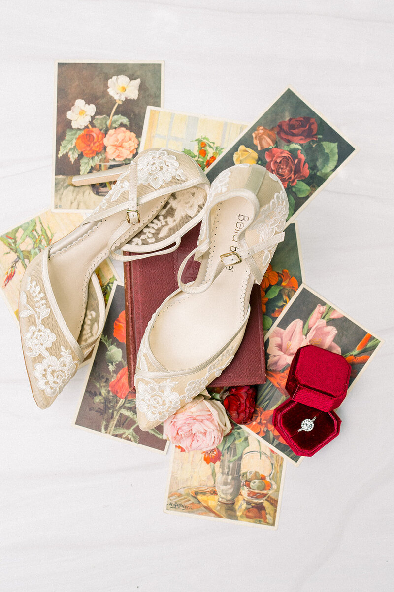 Tiffany Longeway Photography captures the exquisite details of bridal shoes, rings, and floral arrangements in a beautifully styled flat lay at Auberge du Soleil in Napa Valley, California. The luxurious and refined ambiance of the venue enhances the elegance and sophistication of these wedding elements, ideal for couples seeking a high-end and stylish wedding celebration.