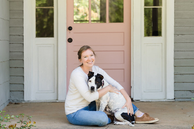 Claire Diana photography sitting with her dog in front of her studio