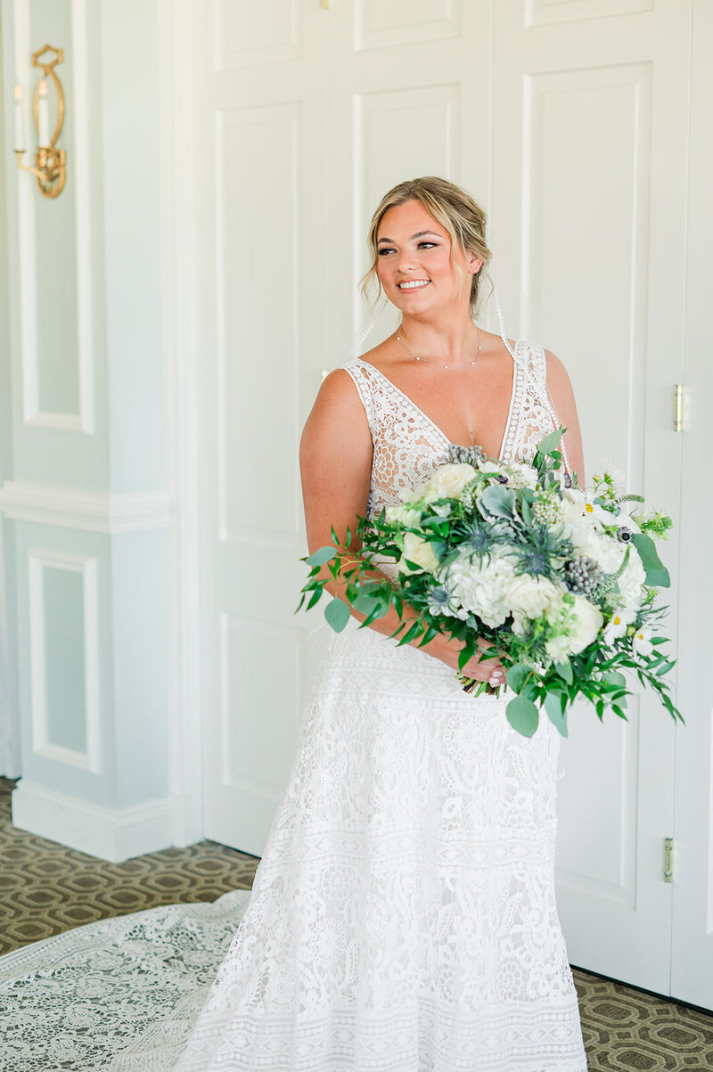 bride in wedding dress holding a white bouquet