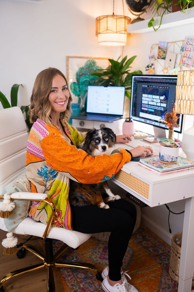 Micaela spinning and laughing in front of a colorful wall at Union Cowork in Encinitas, California
