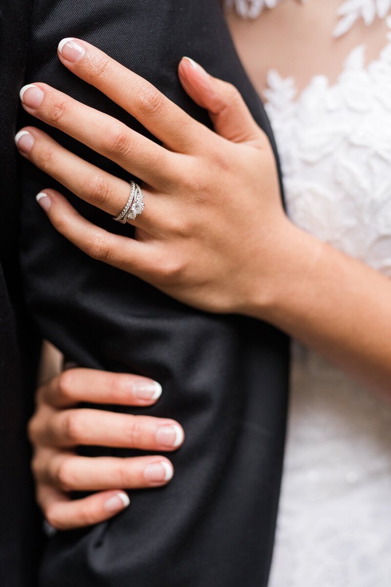 Close up of bride clasping her groom's arm at Mims House in Raleigh, NC, photographed by Raleigh wedding photographer Jenn Eddine.