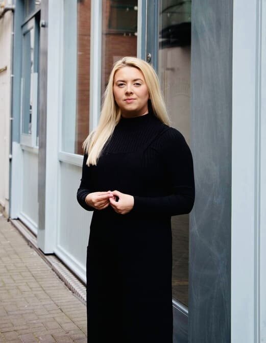 Creative Copywriter Aoibh Johnson standing in front of blue doorway