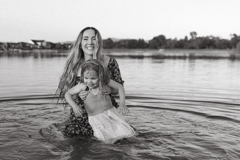 A mom and her daughter playing in the water