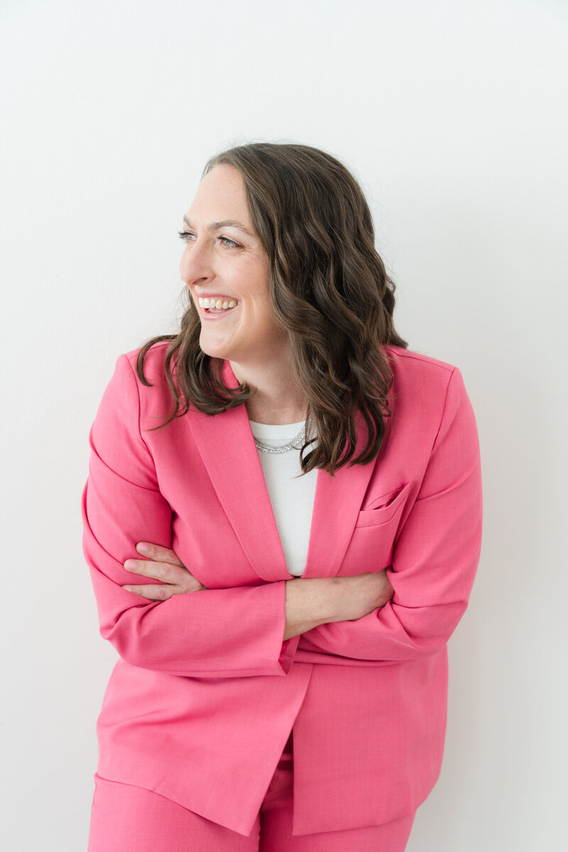 social media strategist and course creator is lying on the white floor and all around her are sticky notes in blue-green and pastel gray. her face is covered by a white paper and she is sleeping in a blue  coat