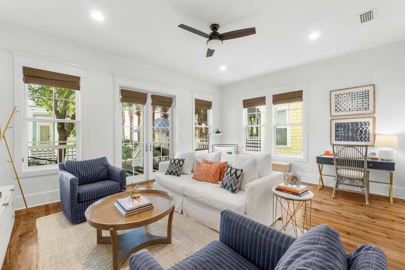 Vibrant living room with cozy seating, ceiling fan, and patio views at a beach rental near Grayton Beach and Alys Beach.
