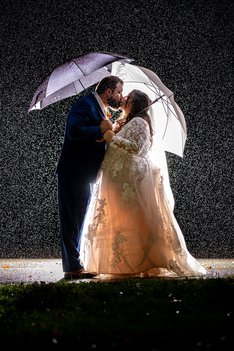 Pennsylvania wedding photo of bride and groom kissing in the rain at their barn wedding venue in pennsylvania