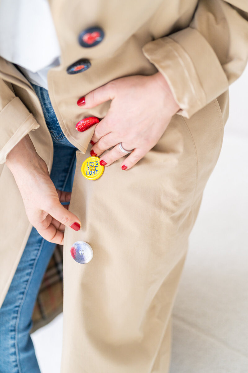detail barevných knoflíků na béžovém kabátu