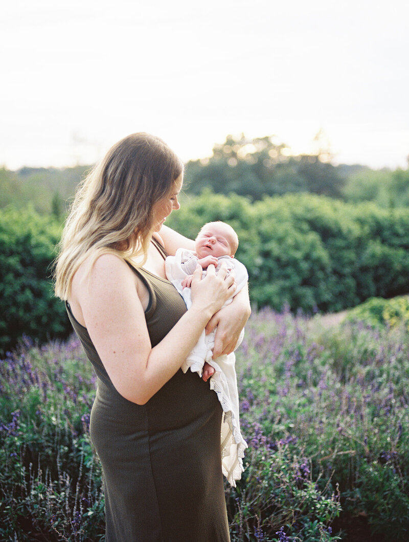 A mother holding her newborn and looking down at the newborn by Katie Stansfield Photography, a Richmond newborn photographer.