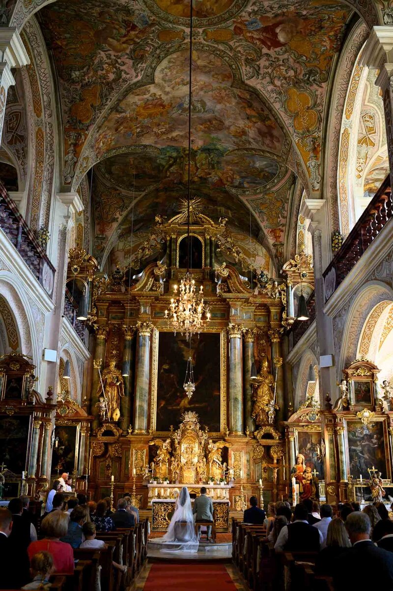 Brautpaar sitzt vor Altar in Klosterkirche Sankt Peter & Paul hochzeit Straubing-Bogen foto  zeigt viel Decke