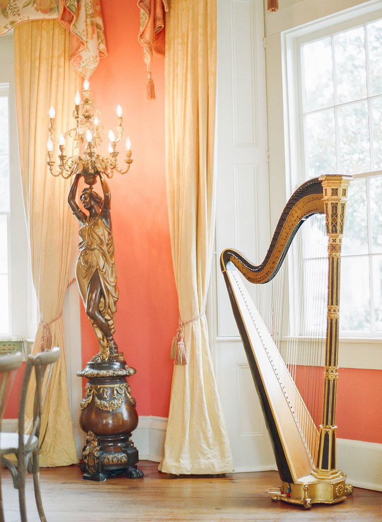 Harp and statue with chandelier inside the William Aiken House
