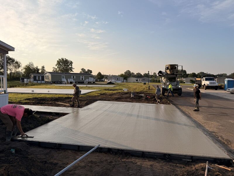 Crew finishing a large commercial concrete slab at sunset in Elkhart, IN