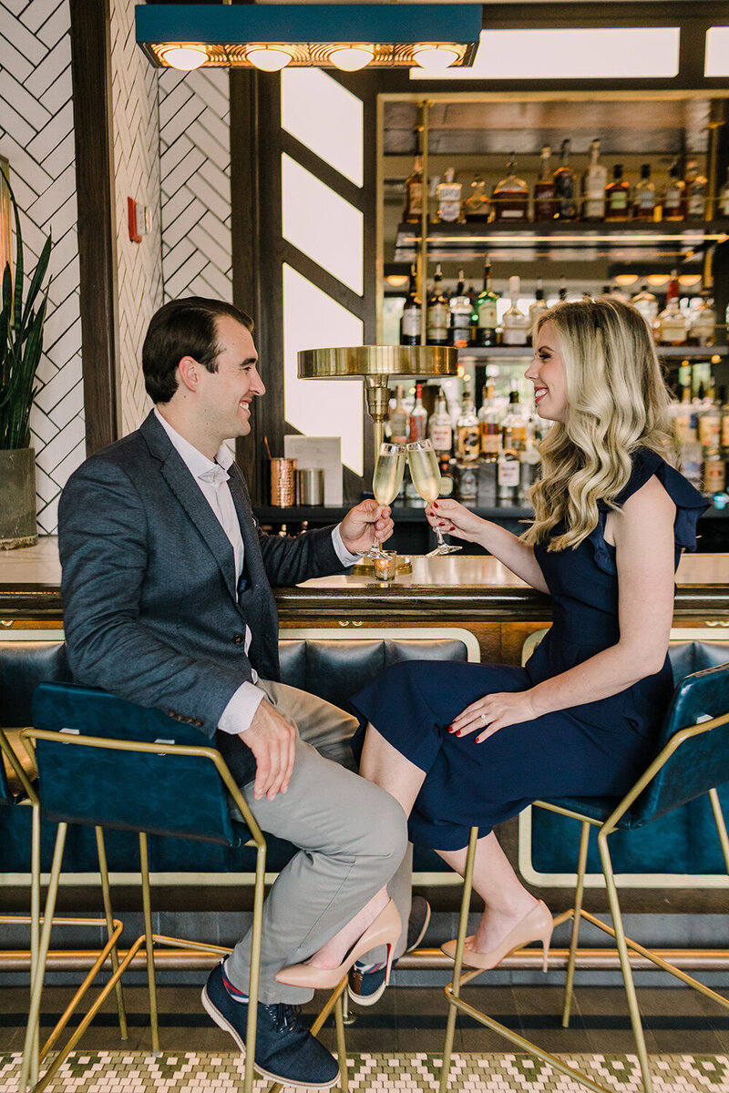 A couple enjoy champagne during their engagement session