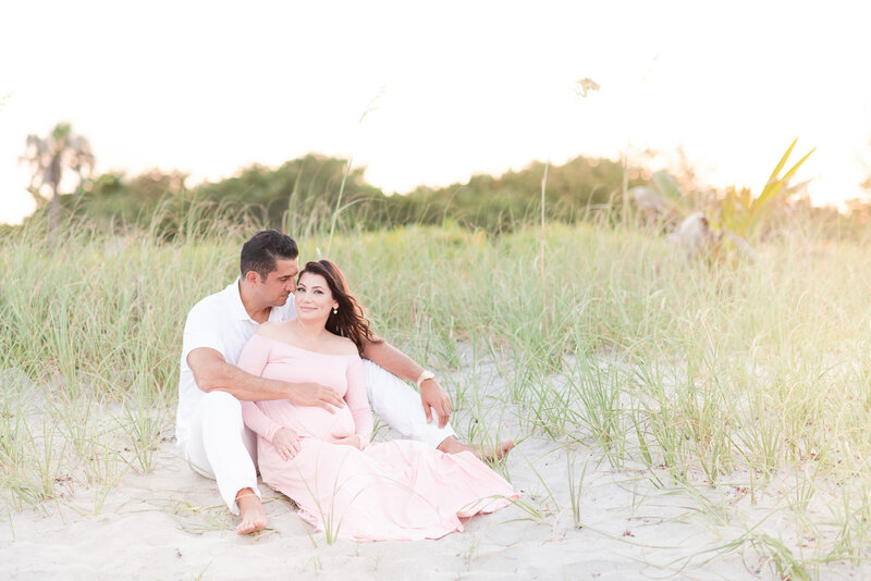 mom and dad sitting on the sand in florida beach by miami maternity photographer msp photography David and Meivys Suarez