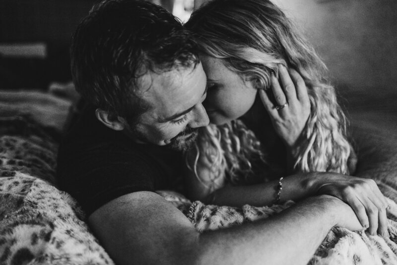 Emotive black and white portrait of a couple holding one another a with their heads together. 