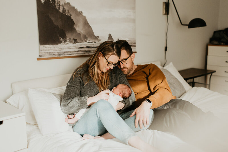 parents with newborn in bed