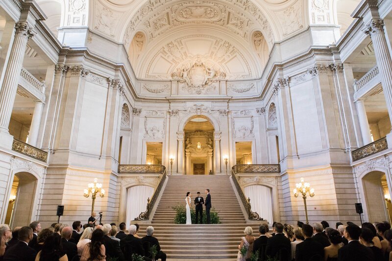 A couple getting married on the grand staircase of San Francisco City Hall