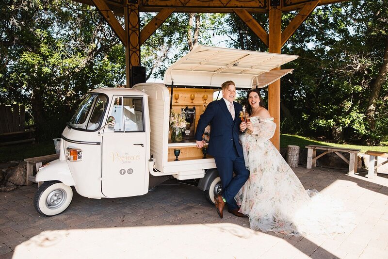 Couple posing with a prosecco cart