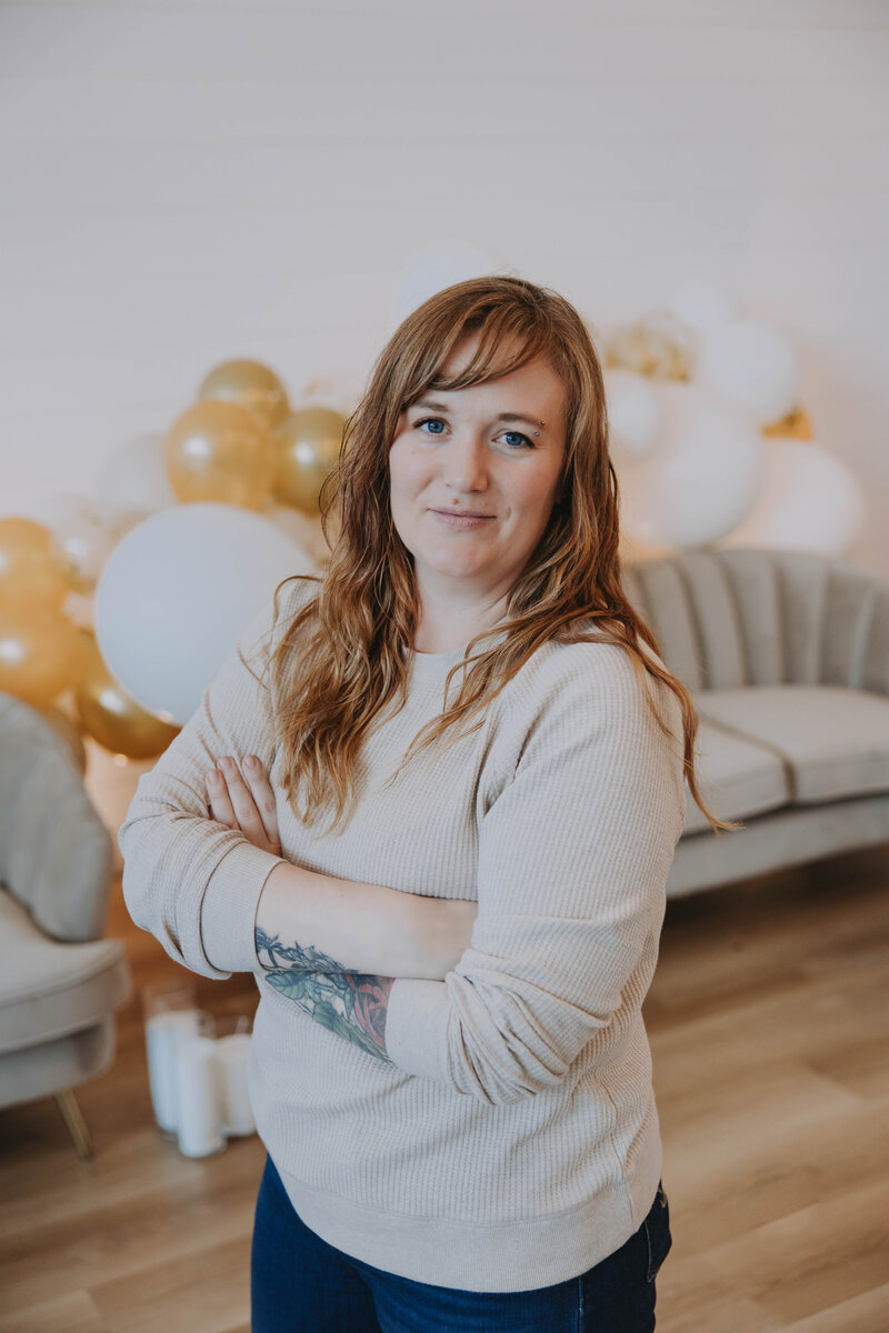 Event planner in cozy winter outfit and grey beanie smiling in snowy Banff forest – Rocky Mountain Wedding Collective