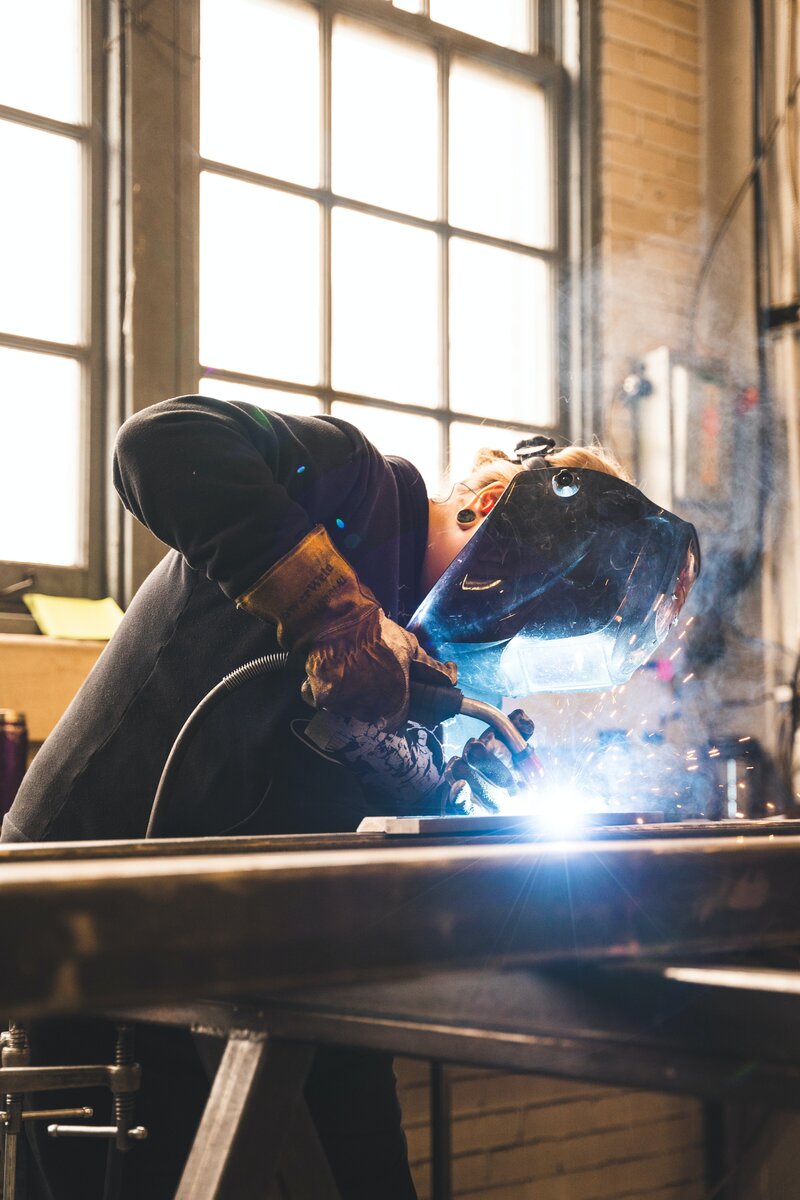 Man completing a welding project in garage