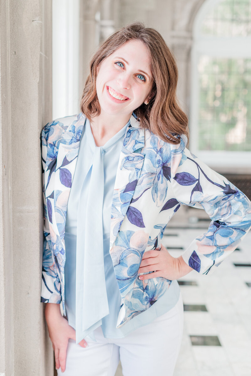 Woman smiling at the camera wearing a blue floral blazer