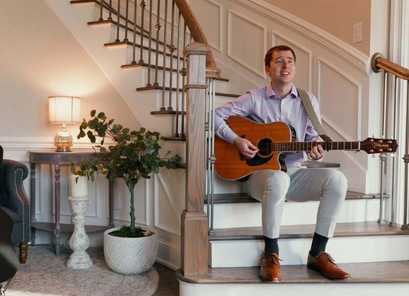 A person sitting on the stairs playing guitar 