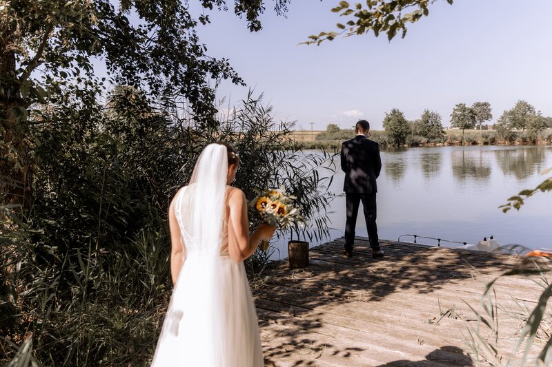 Frau laueft auf Mann zu der mit dem Ruecken zu ihr steht