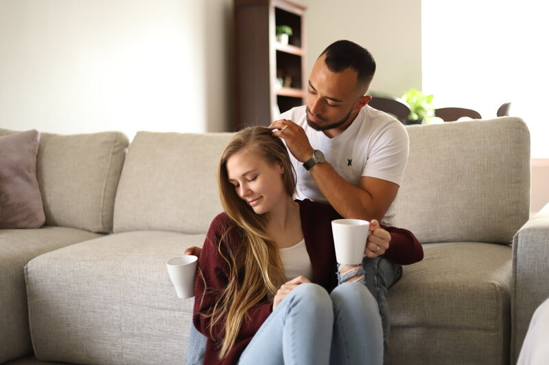 Couple enjoying coffee and tender moments on their sofa in their home