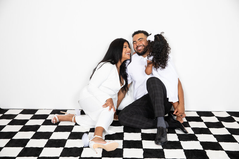 A couple posing happily on a checkered floor, captured by an Austin wedding photographer.