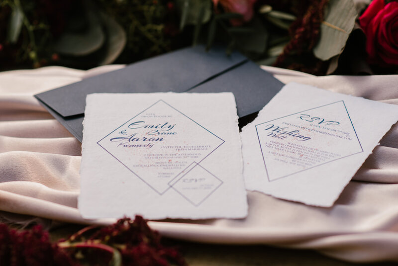 Close up of white handmade cotton paper wedding invitations with soft deckled edge and diamond design