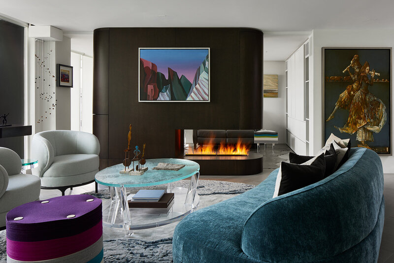 A minimalistic  condo living room featuring plush couches, a fireplace, and client artwork
