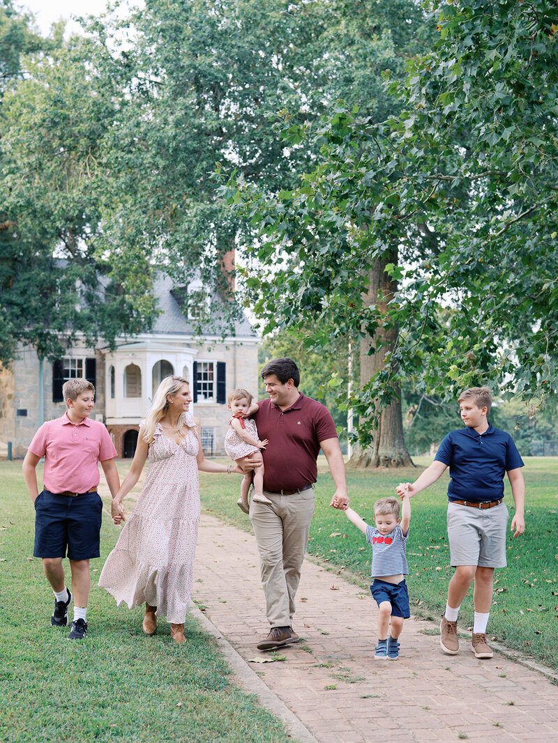 A family holding hands and walking by Katie Stansfield Photography, a Richmond family photographer.