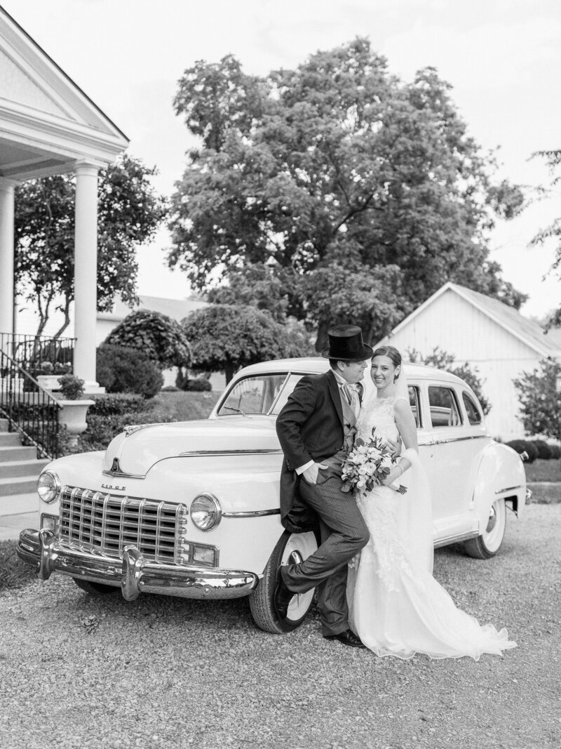Bride and groom in front of vintage car photographed by Cincinnati Catholic wedding photographers Laura and Matthew