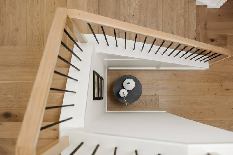 A beautiful white oak staircase with black iron spindles. 