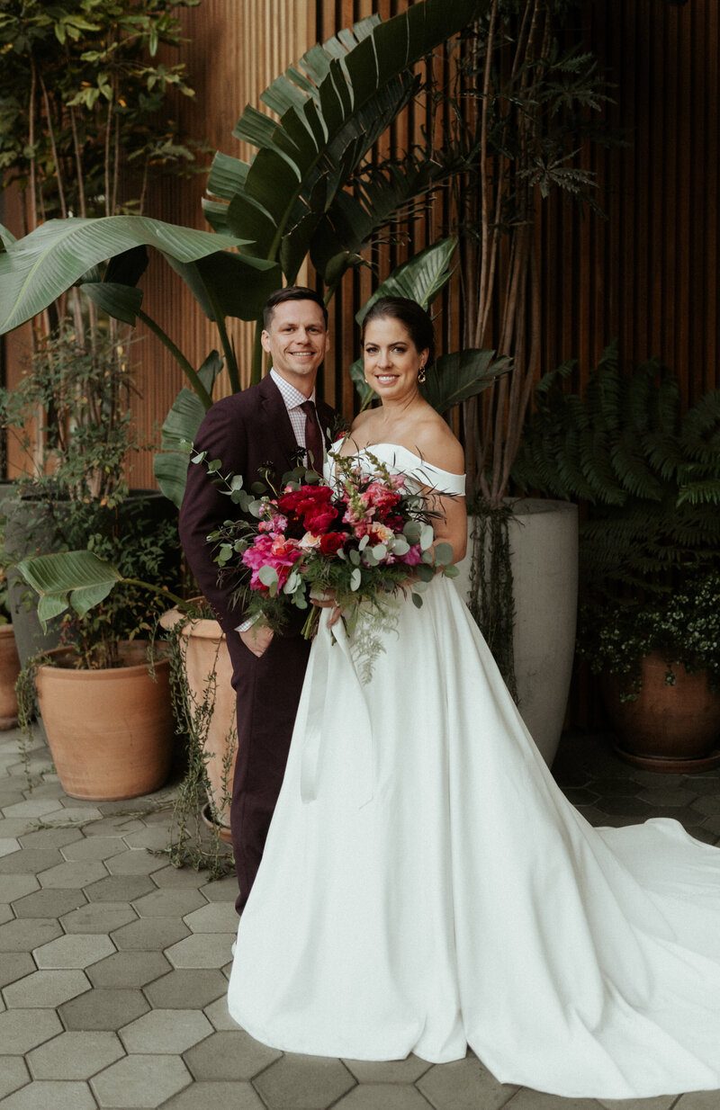 Bride and groom rest on gold velvet setee on their wedding day