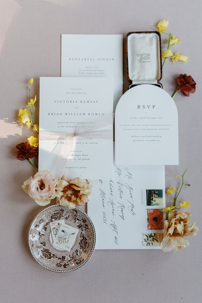 Photograph of bespoke, antique inspired wedding invitations styling in a flatlay. 