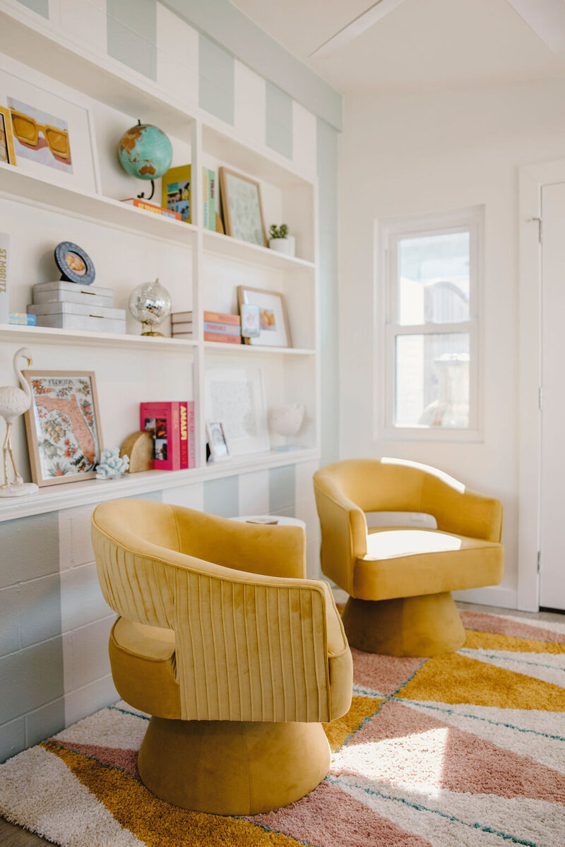 built-in bookshelf, yellow chairs, and blue and white striped wall