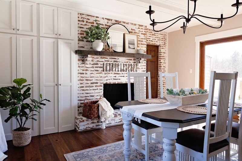 Farmhouse dinning room featuring a worn white washed textured fireplace.