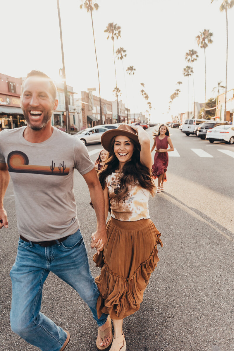 an image of a family running down the street in southern california taken by Christine Dammann photography and edited using Imagen AI editing services.